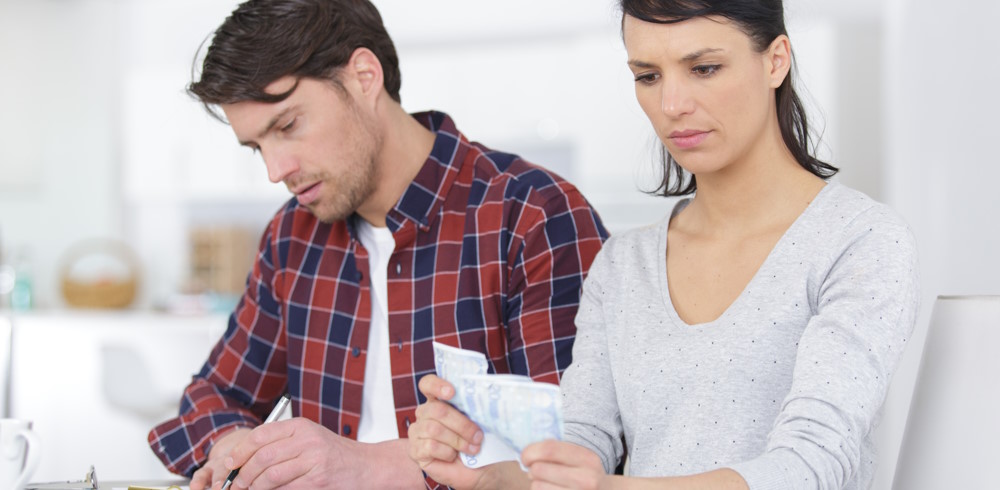 couple embracing and calculating the bills