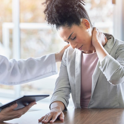 Doctor consulting woman with neck pain