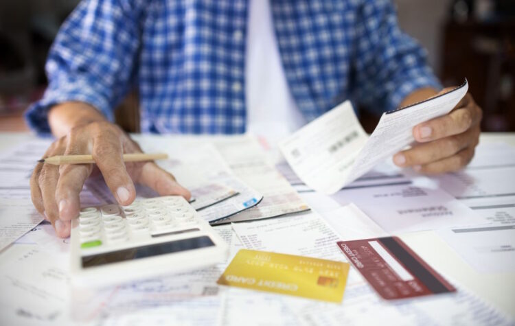 man sitting at desk calculating expenses man sitting at desk calculating expenses