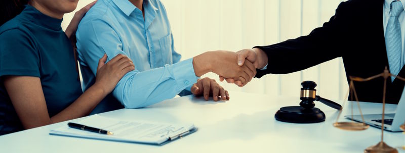 Couple shaking hands with their lawyer