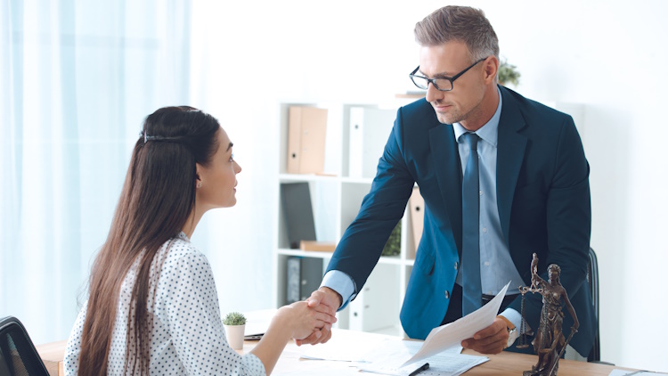 lawyer and young female client shaking hands lawyer and young female client shaking hands