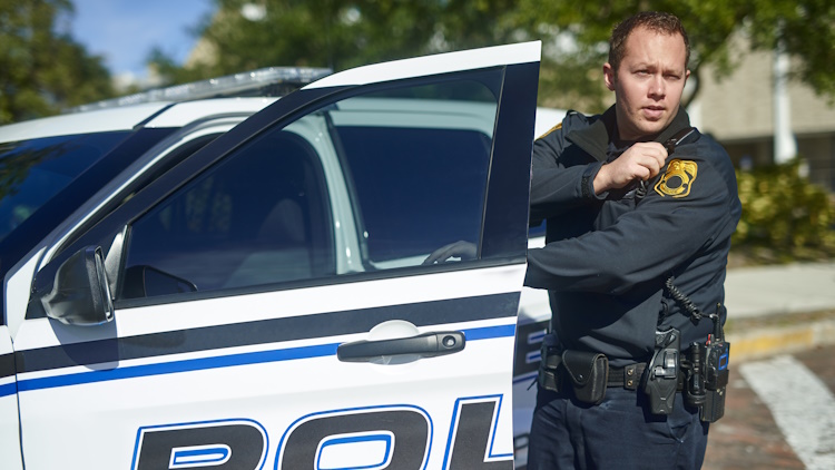 young policeman radioing in to headquarters