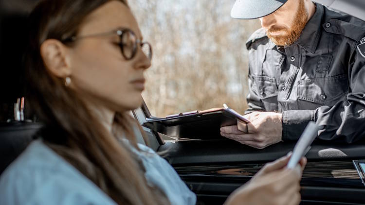 Policeman checking documents of a young female driver