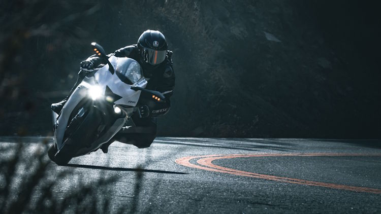 Motorcyclist riding a sport motorcycle on a winding road